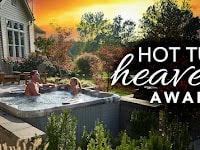 Couple enjoying an award-winning Aspen Spa hot tub in a beautiful backyard